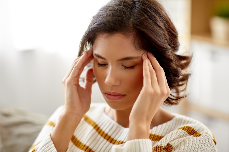unhappy woman suffering from head ache at home